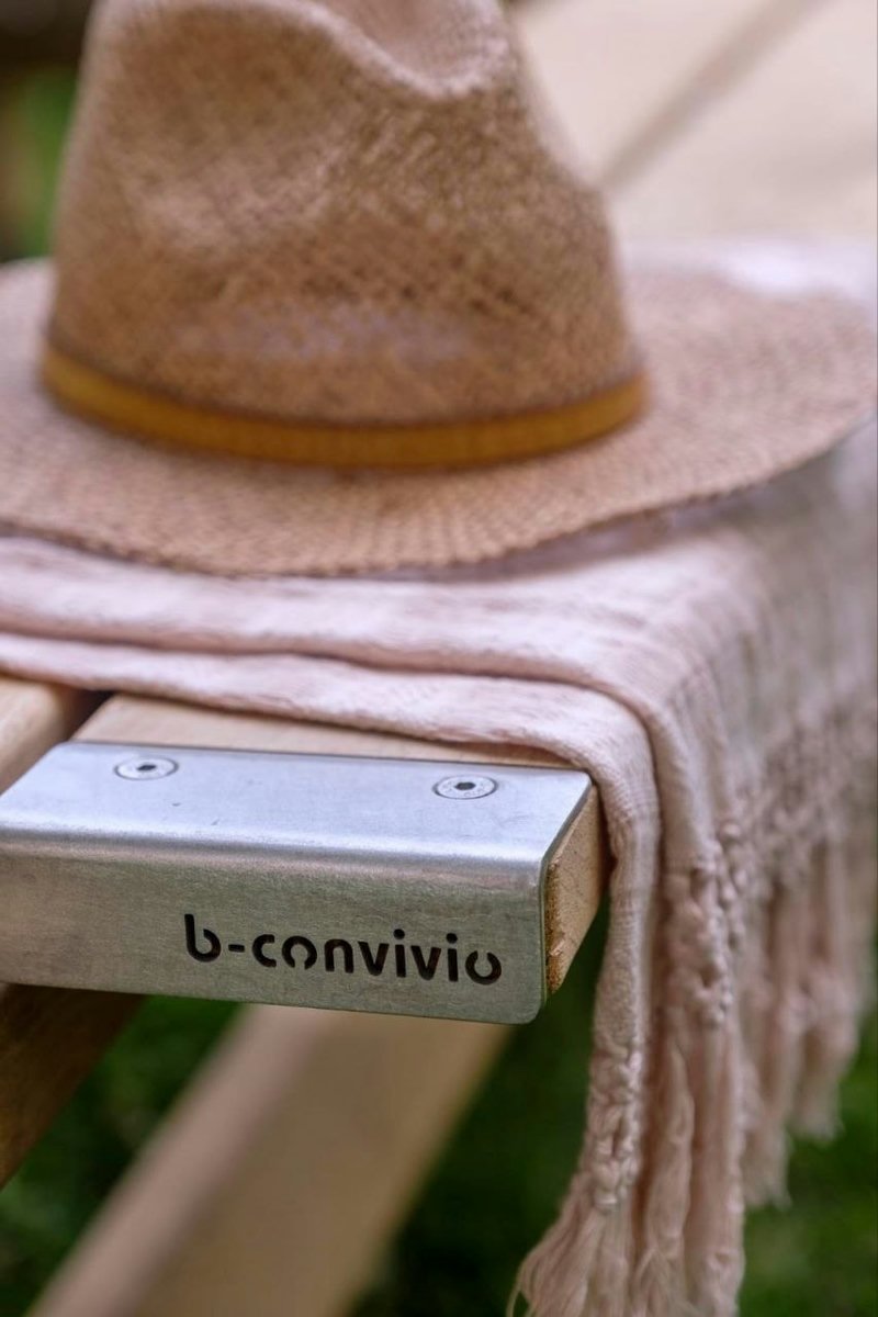 Gros plan sur la plaque métal gravée b-convivio sur l'accoudoir du banc